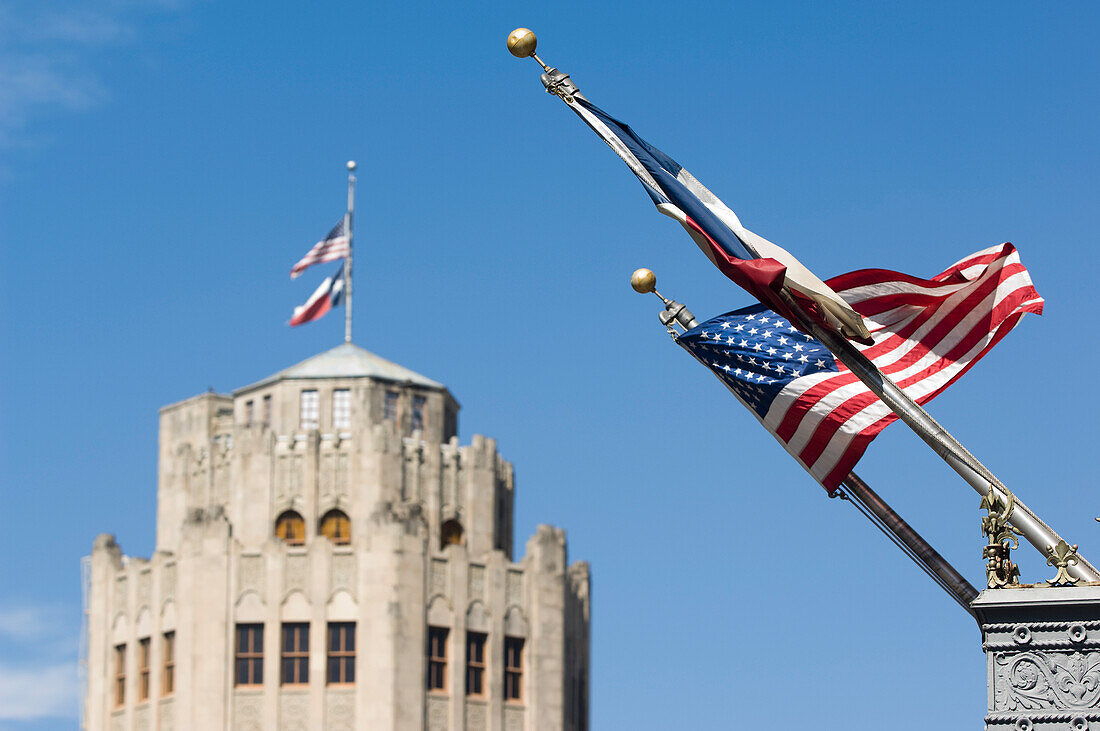 Altes San-Antonio-Nachrichtengebäude im Hintergrund mit Sternen und Streifen (US-Flagge) und Lone Star (Texas-Flagge) im Vordergrund, San Antonio, Texas, USA