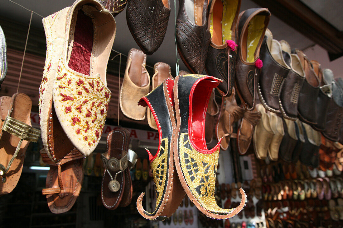 Lederschuhe und andere touristische Waren zum Verkauf in diesem Geschäft in der Nähe des Hawa Mahal City Palace, Jaipurs Wahrzeichen, Jaipur, Rajasthan State, Indien.