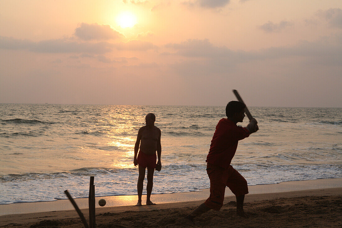 Playing cricket,the national sport of India,on Anjuna Beach at sunset,Goa State,India,Asia.