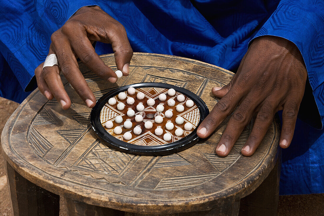 Niger,Nord-Niger,Air Region,Tuareg Mann spielt "Solitaire" traditionelles Spiel,Agadez