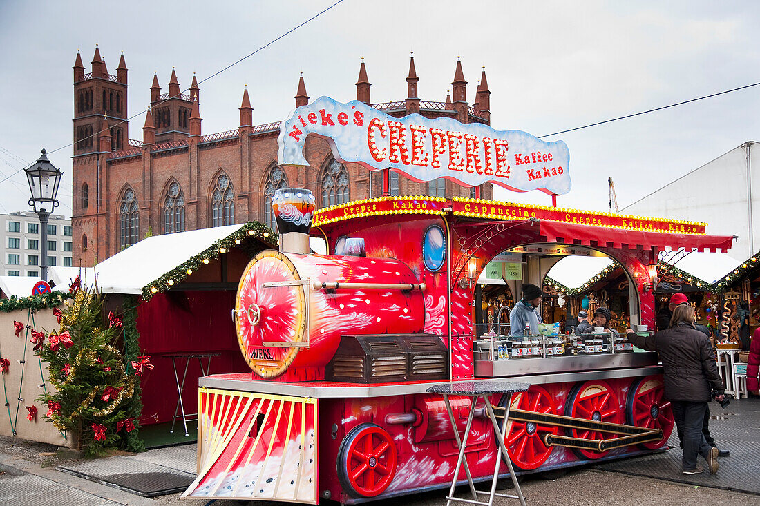 Germany,drink and gifts. Christmas Markets,Berlin,St Hedwigs Catherdral in background. stall in shape of a steam train stalls selling festive food