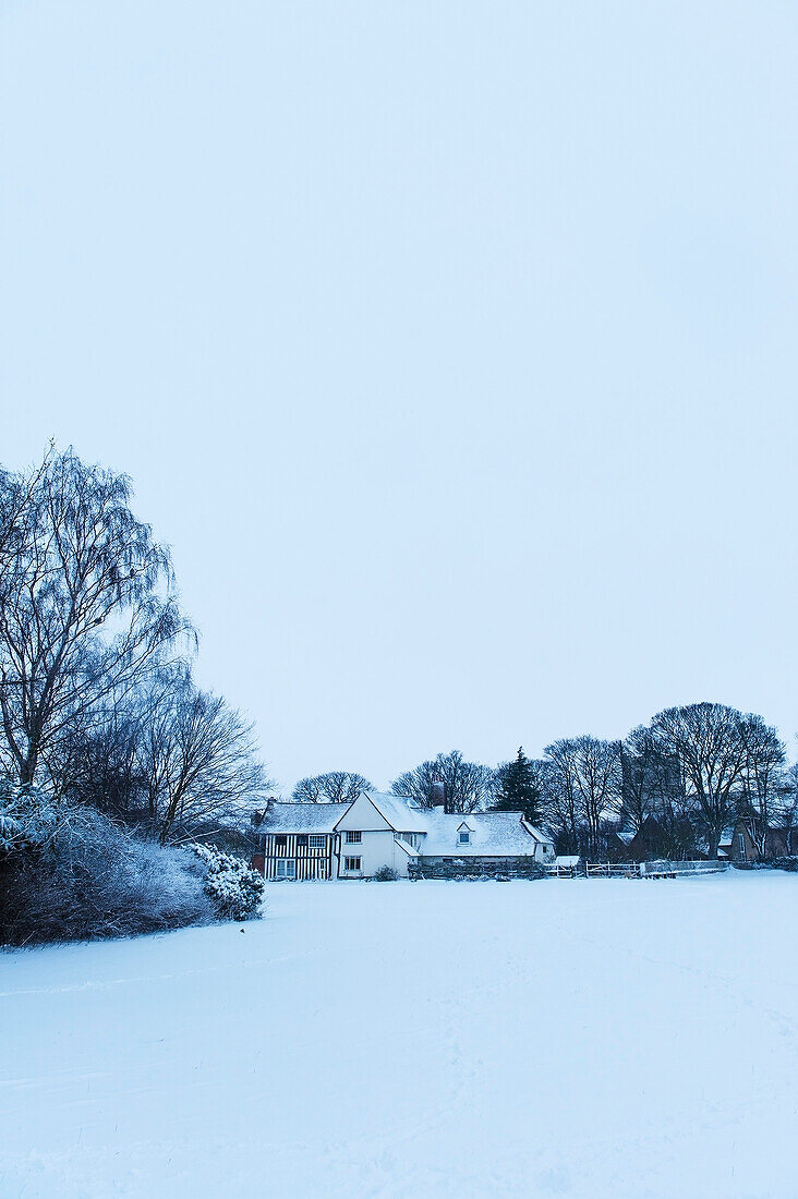 Mittelalterliches Haus und verschneites Feld, Great Wilbraham, Cambridgeshire, England, Großbritannien