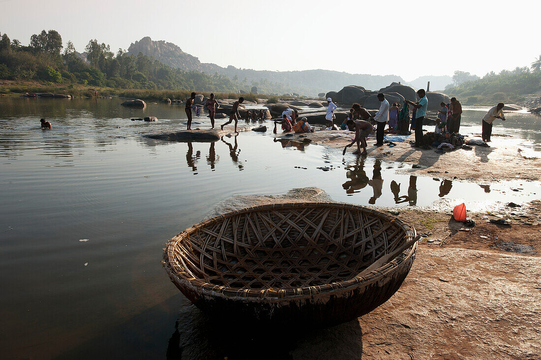 Waschen und Reinigen von Kleidung im Fluss, Hampi, Karnataka, Indien