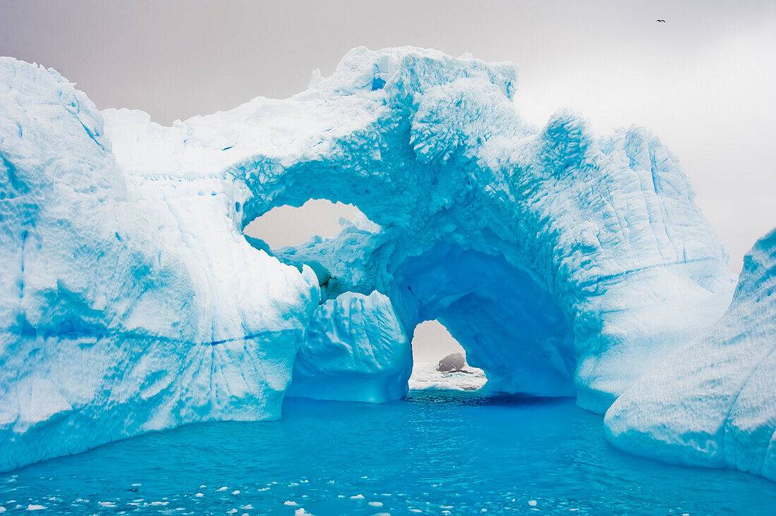 Natürliche Bogenbildung in einem Eisberg in der Cierva-Bucht des Südlichen Ozeans, Antarktis