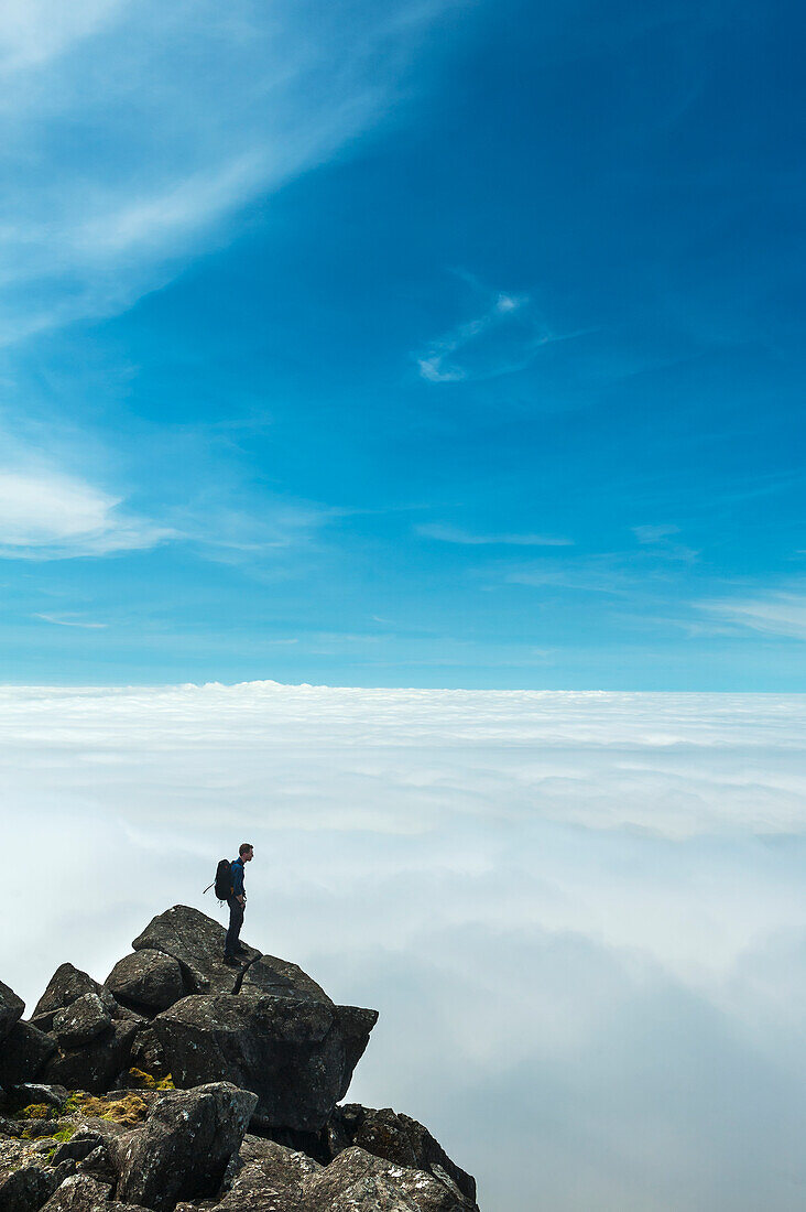 Ein Wanderer bewundert die Aussicht vom Gipfel des Sgurr Nan Eag, einem der Gipfel in den Black Cuillin, Isle Of Skye, Schottland
