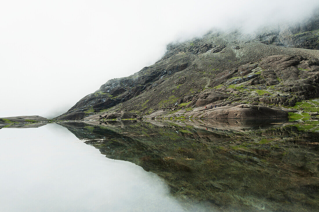 Spiegelungen in einem vollkommen stillen kleinen See unterhalb von Sgurr Dearg und Sgurr Alasdair in der Black Cuillin, Isle Of Skye, Schottland