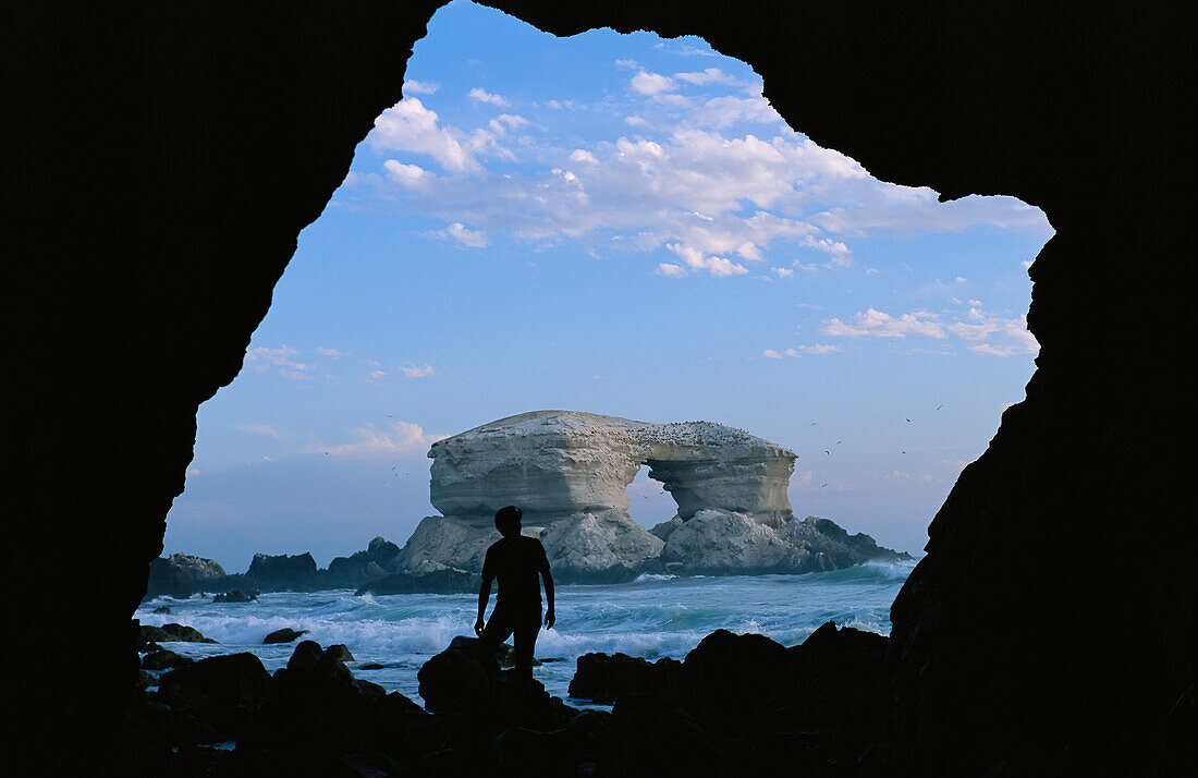 Mann mit Silhouette vor dem La Portada-Felsbogen an der Küste Chiles, La Portada, Antofagasta, Chile