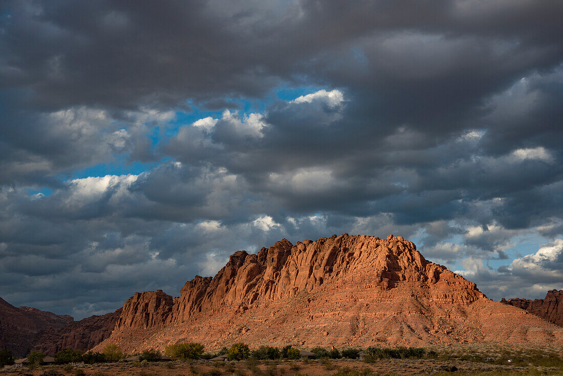 Hiking trail through Snow Canyon,behind the Red Mountain Spa on Red Cliffs Desert Reserve around St George Town with red,rock cliffs and dark clouds in a blue sky,St George,Utah,United States of America