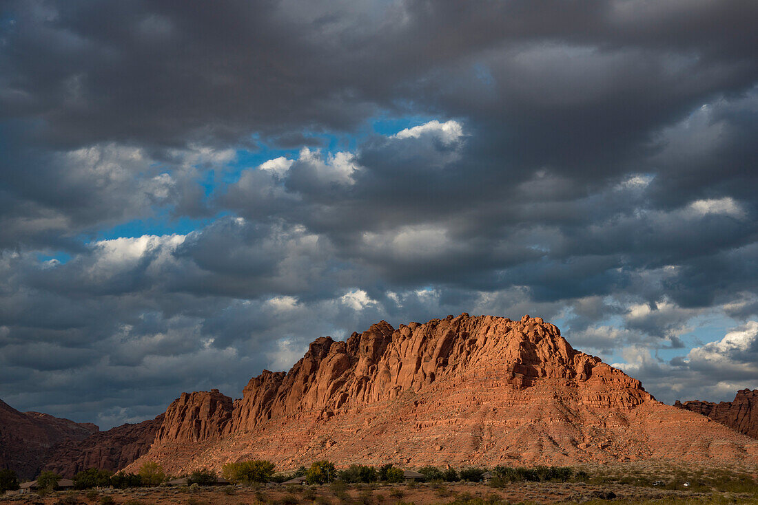 Wanderweg durch den Snow Canyon, hinter dem Red Mountain Spa am Red Cliffs Desert Reserve um St George Town mit roten Felsen und dunklen Wolken am blauen Himmel, St George, Utah, Vereinigte Staaten von Amerika