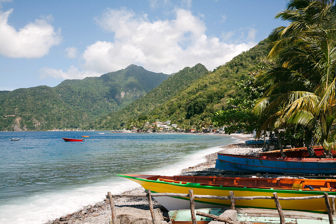 Küstenlandschaft, malerischer Blick auf traditionelle Einbäume, die am Ufer des kleinen Dorfes Scotts Head in der Soufriere Bay auf der Insel Dominica gestrandet sind, Soufriere, Dominica, Karibik