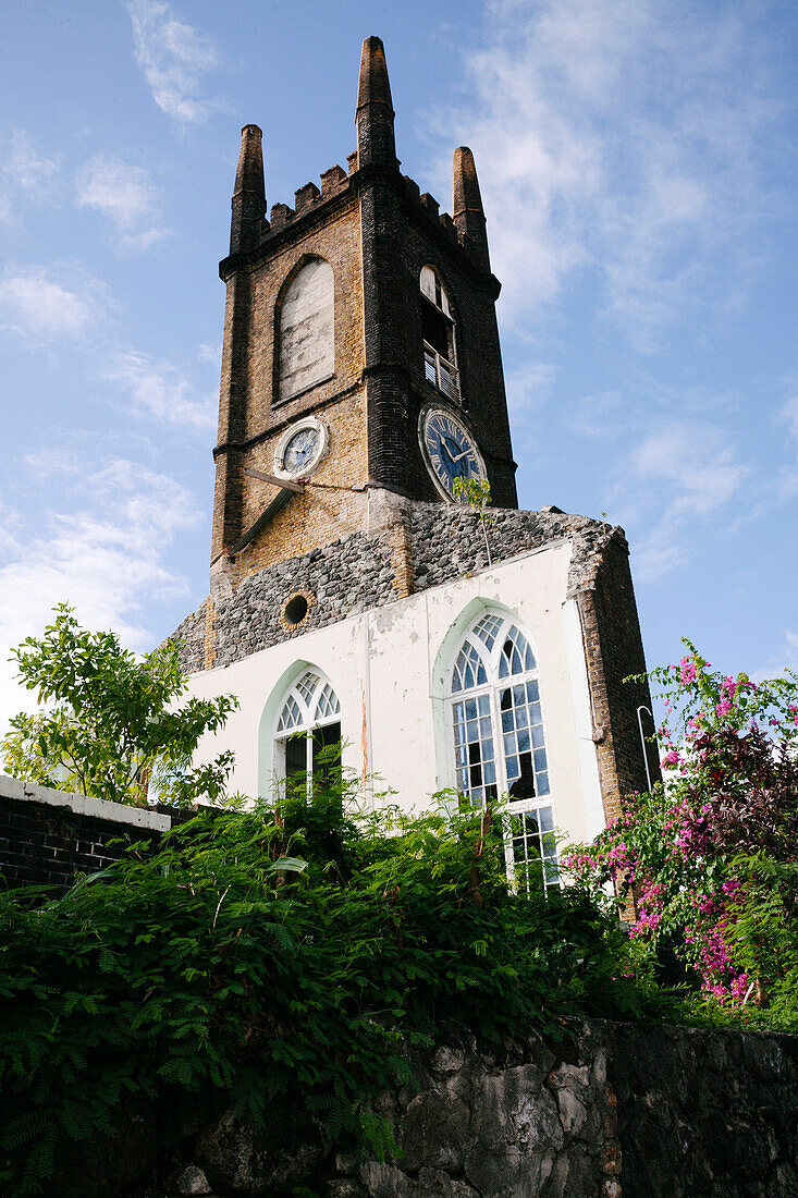 Close-up view of the clock tower and stone wall with windows against a blue sky,the remnants of St Andrew's Presbyterian Church (which was heavily damaged in 2004 from Hurricane Ivan) in the port city capital of St Georges on the Island of Grenada,St Georges,Grenada,Caribbean