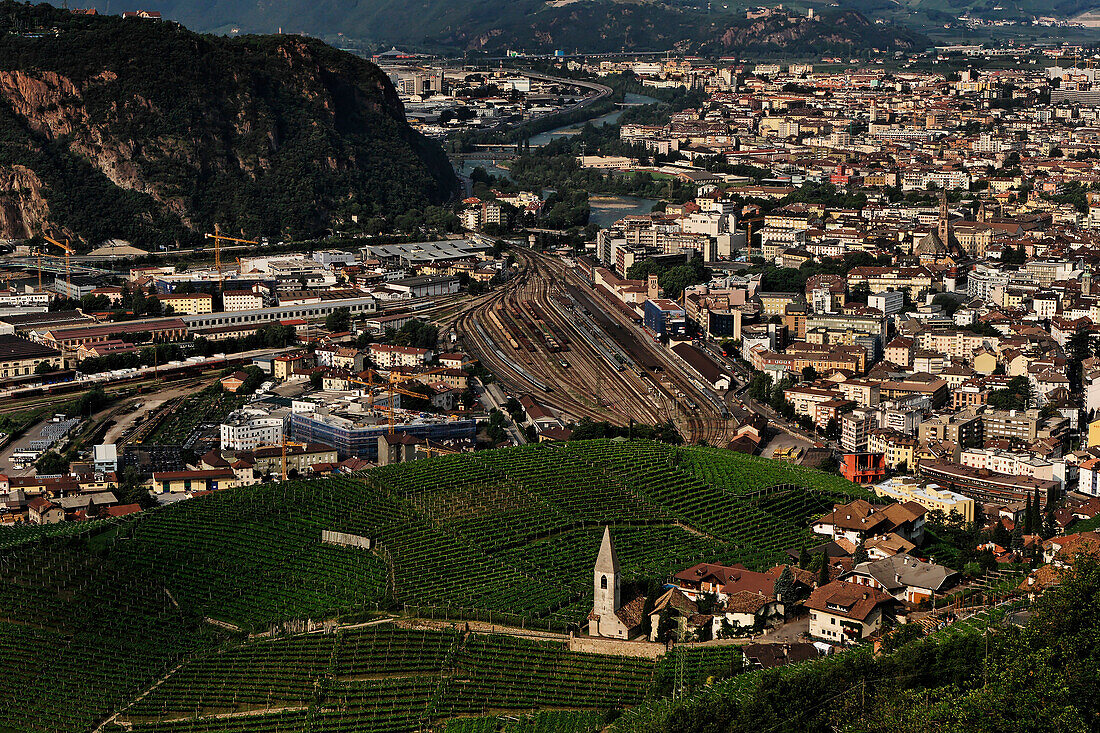 Blick aus der Vogelperspektive auf einen Weinberg, eine Kirche und die Stadt Bozen, Italien, Balzano, Italien