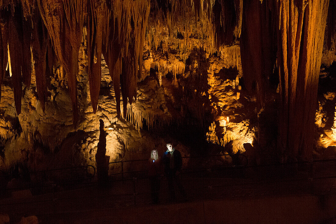 Mann und Frau beleuchtet bei der Erkundung der Luray Caverns, Luray, Virginia, Vereinigte Staaten von Amerika