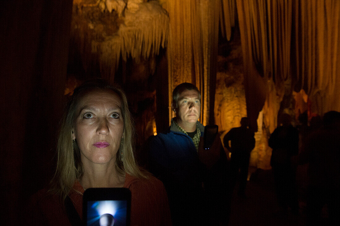 Mann und Frau beleuchtet bei der Erkundung der Luray Caverns, Luray, Virginia, Vereinigte Staaten von Amerika
