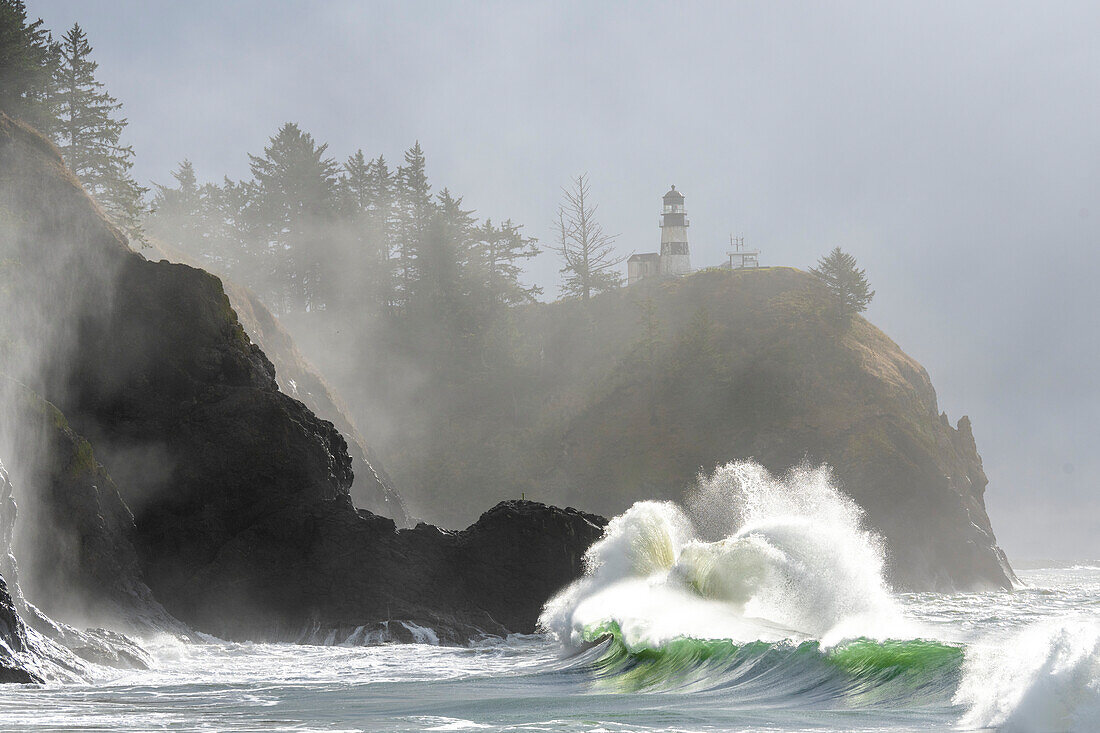 Morgennebel verstärkt die dramatische Schönheit der gegen die Klippen krachenden Wellen am Cape Disappointment Lighthouse an der Mündung des Columbia River im Südwesten Washingtons,Washington,Vereinigte Staaten von Amerika