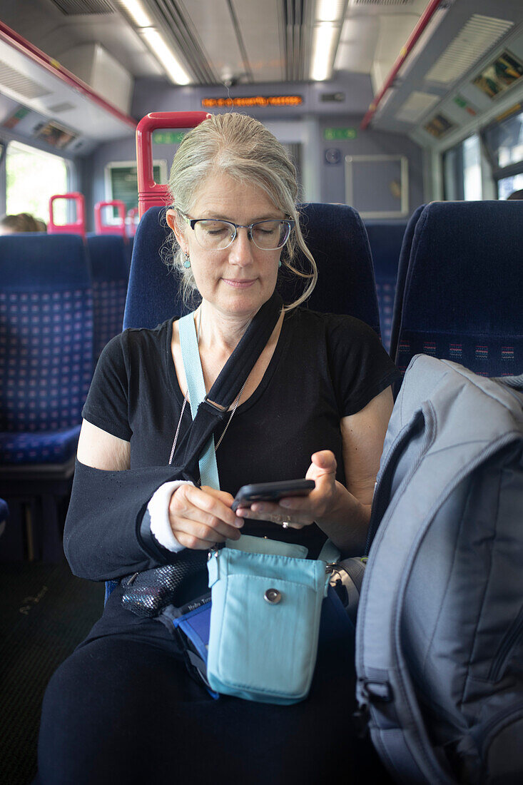 Mature woman rides public transit,and uses her smart phone