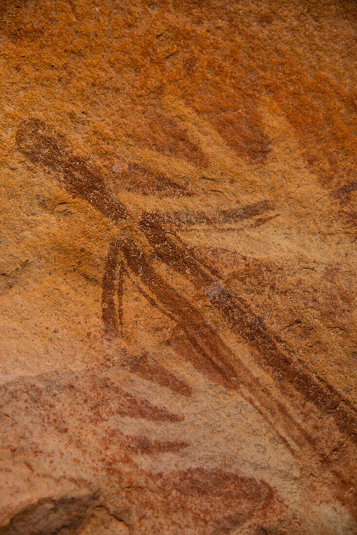 Stilisierte menschliche Figur, überlagert von zwei Schablonenbildern der rechten Hand, Teil der Bradshaw Rock Paintings-Sammlung prähistorischer australischer Kunst, Kimberley, Westaustralien, Australien