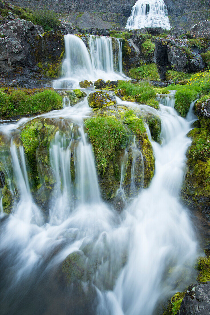 Zwei kleine Wasserfälle und der größere Dynjandi-Wasserfall im Hintergrund, Island