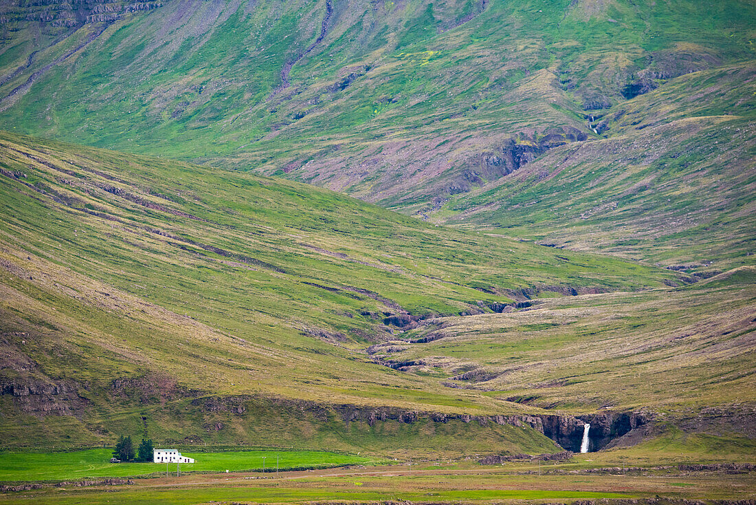Aussicht auf einen Wasserfall und ein Haus in Island,Island
