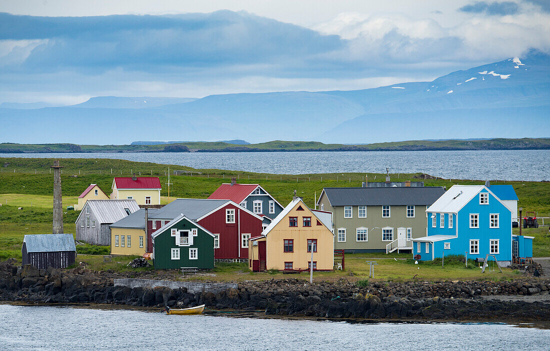 Bunte Häuser auf der Insel Flatey mit Bergen und Wasser im Hintergrund, in der Region Breidafjordur in den Westfjorden, Island, Island