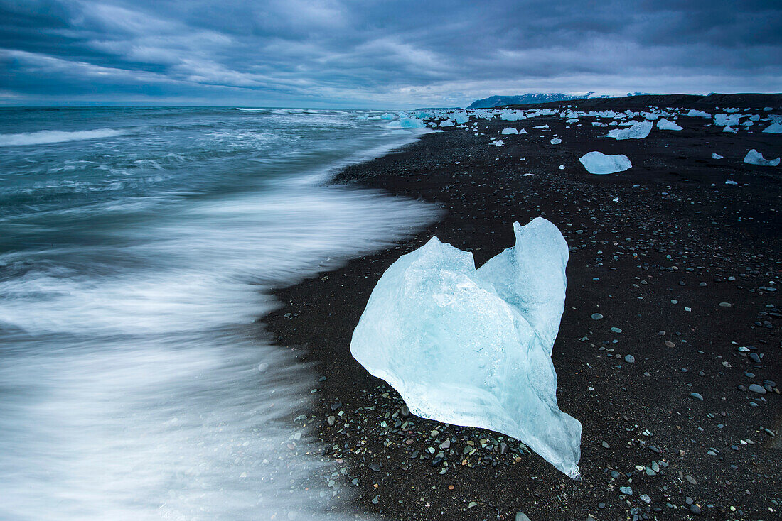 Eisberg in der Lagune von Jokulsarlon an einem schwarzen Sandstrand, Island