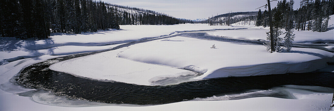 Winterpanorama des schneebedeckten Lewis River im Yellowstone National Park, Wyoming, Vereinigte Staaten von Amerika