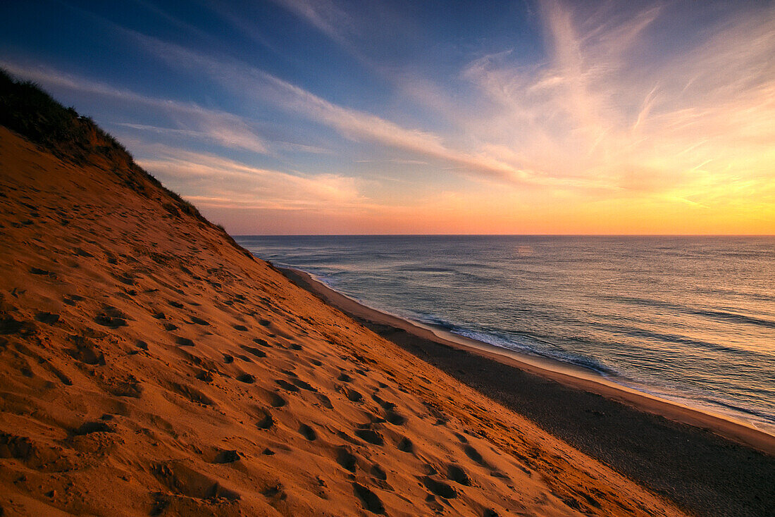 Sonnenaufgang färbt den Himmel orange über der Küste von Coastguard Beach, Cape Cod, Massachusetts, Vereinigte Staaten von Amerika