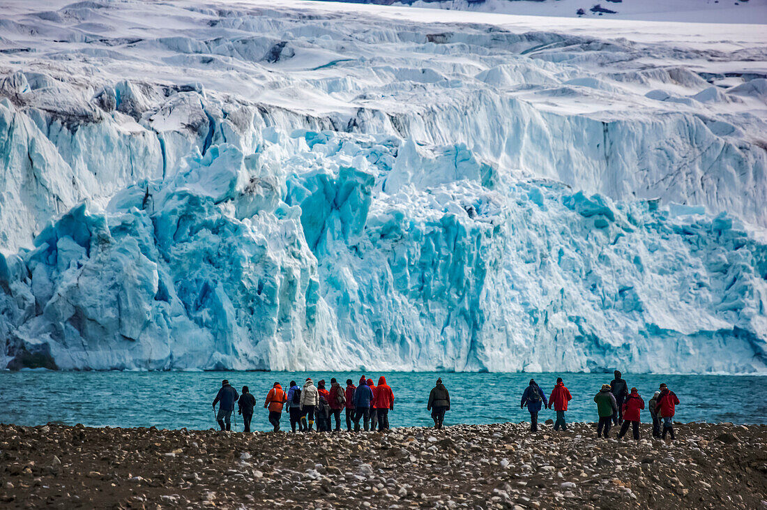 Ecotourists near a blue ice glacier above Krossfjord,Spitsbergen,Svalbard Archipelago,Norway