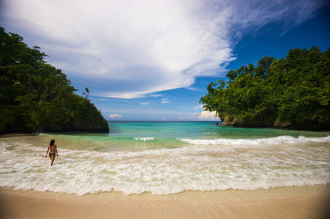 Frau watet in der Brandung an der Frenchman's Cove in Tobago, Port Antonio, Jamaika