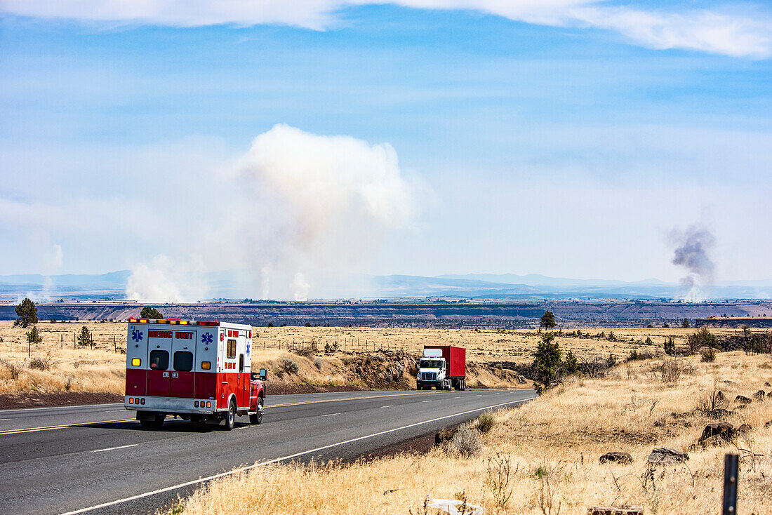Ein Einsatzfahrzeug, das auf dem US Highway 26 in Richtung mehrerer Waldbrände in der Nähe von Madras und Metolius in Zentral-Oregon während der Trockenzeit 2018 rast, Oregon, Vereinigte Staaten von Amerika