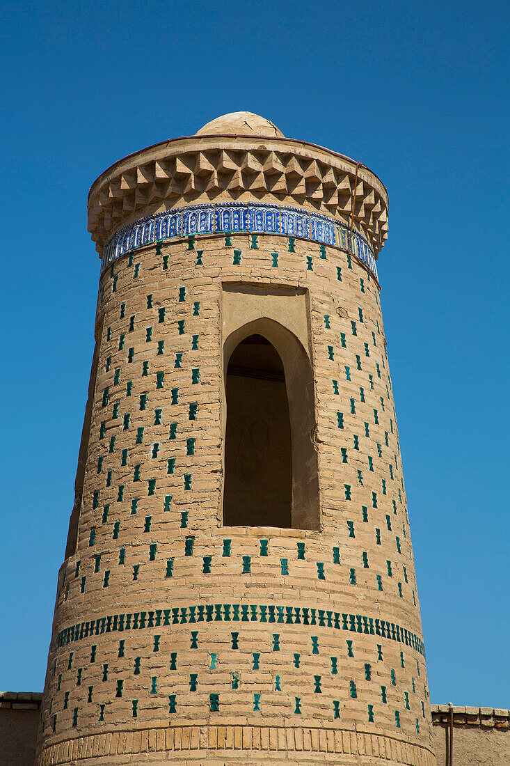 Tower with decorative pattern against a clear blue sky in Itchan Kala,Khiva,Uzbekistan