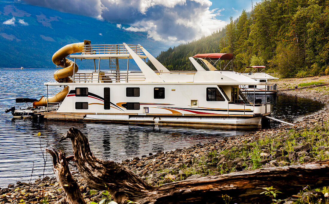 Vacation houseboats parked at a dock on the shoreline of Shuswap Lake,Shuswap Lake,British Columbia,Canada