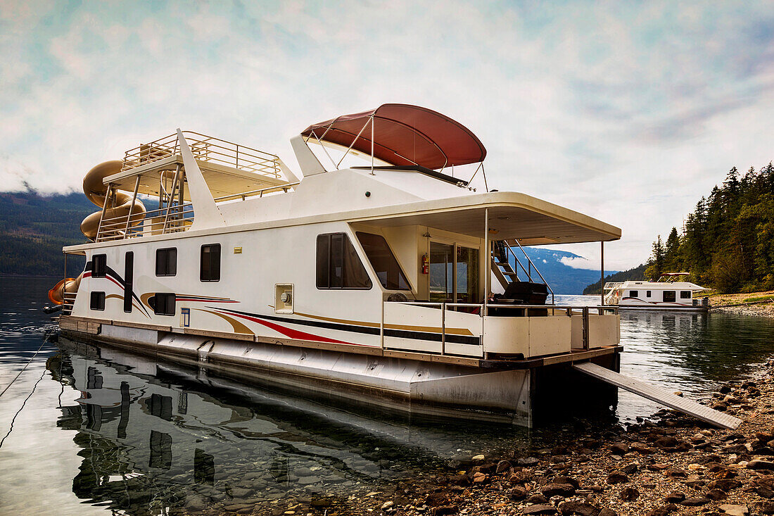 Vacation houseboats parked at a dock on the shoreline of Shuswap Lake,Shuswap Lake,British Columbia,Canada