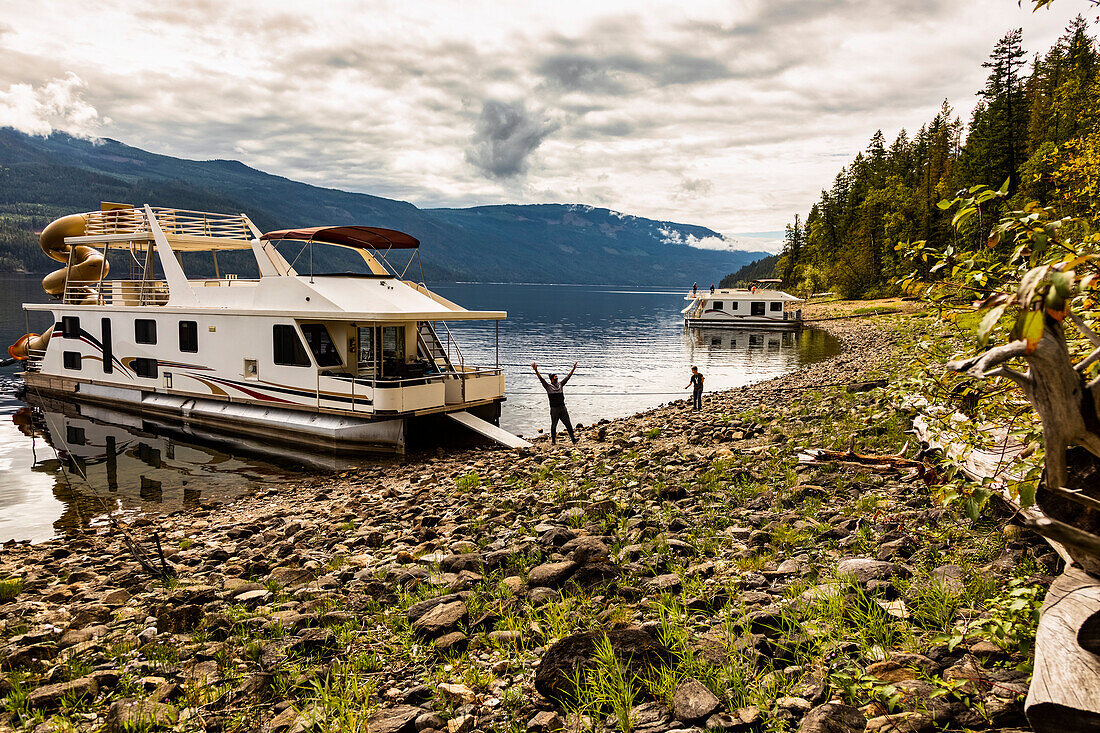 Eine Familie genießt ihren Urlaub auf einem Hausboot am Ufer des Shuswap Lake, Shuswap Lake, British Columbia, Kanada