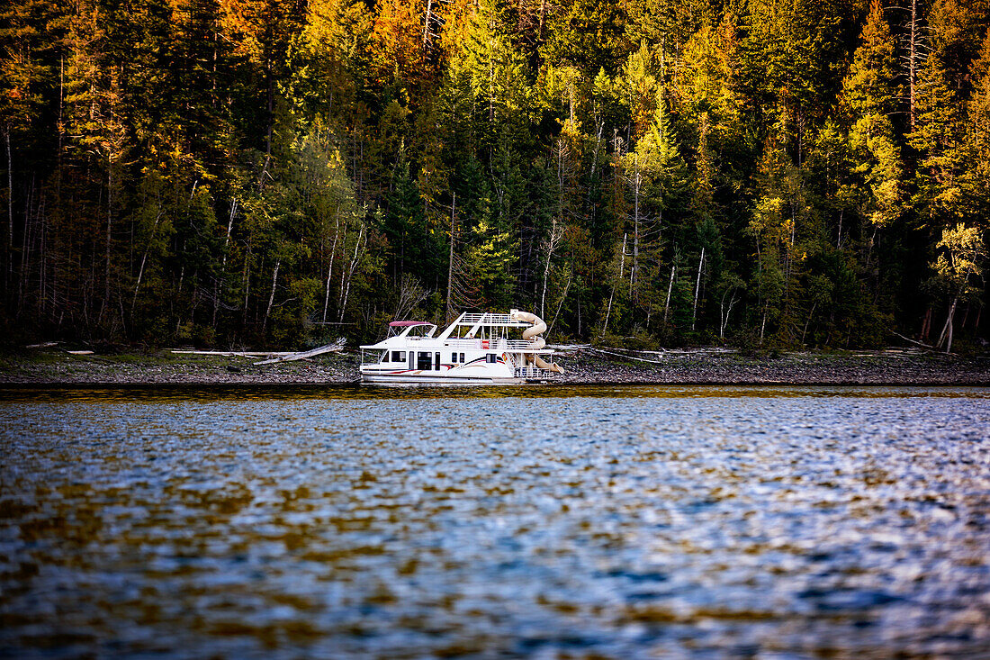 A vacation houseboat parked on the shoreline of Shuswap Lake in autumn,Shuswap Lake,British Columbia,Canada