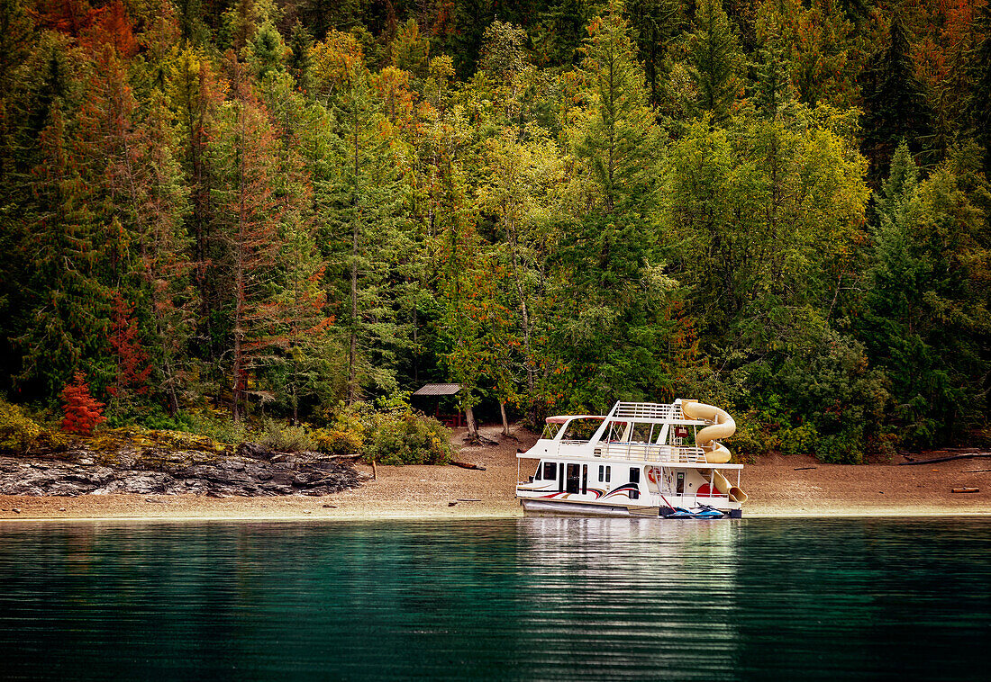 A vacation houseboat parked on the shoreline of Shuswap Lake in autumn,Shuswap Lake,British Columbia,Canada