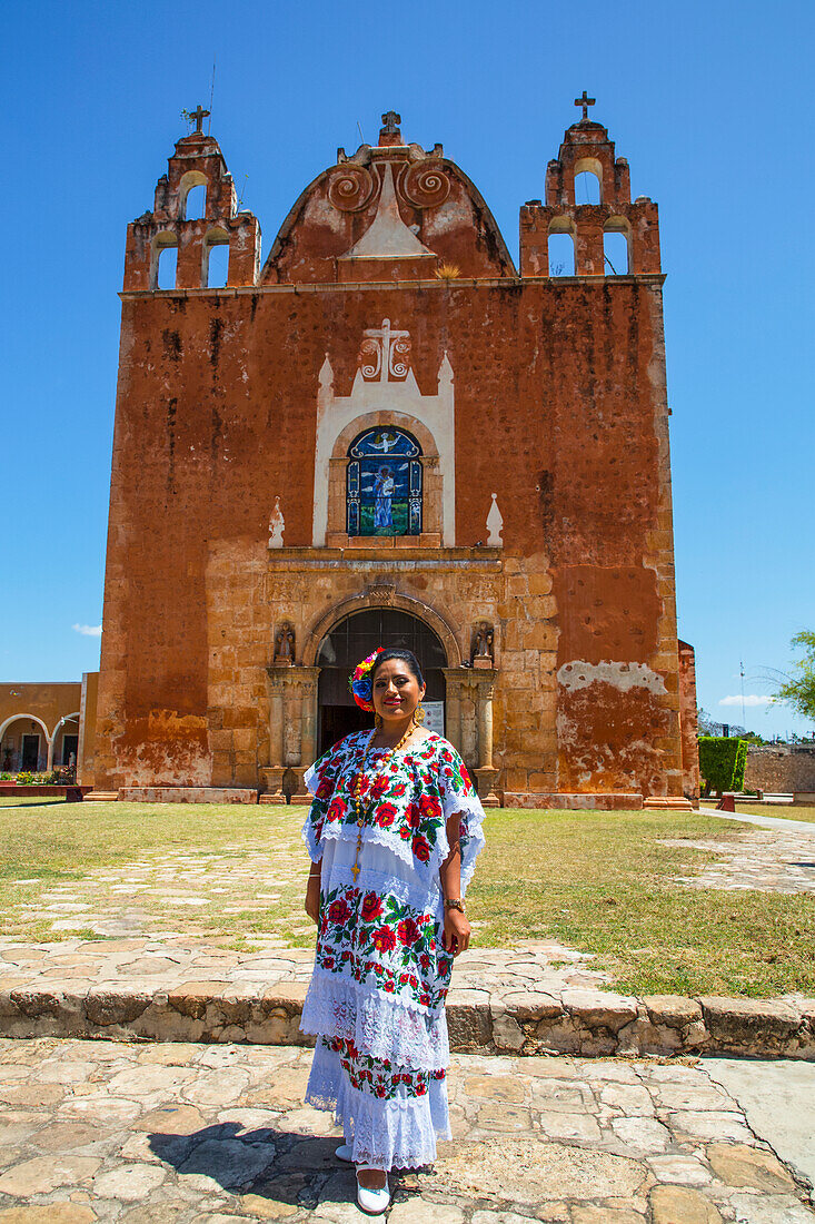 Maya-Frau in traditioneller Kleidung vor der Kirche von San Antonio de Padua, einem ehemaligen Kloster, in Ticul, Yucatan, Mexiko