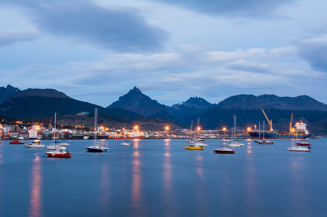 Port city shown in blue hour with boats mooring and street lights reflecting in the water,Ushuaia,Tierra del Fuego,Argentina