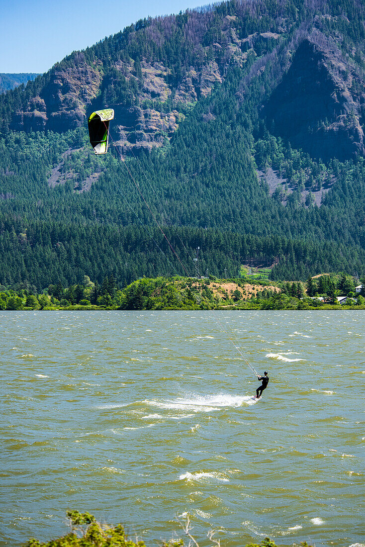 A kite surfer enjoying the strong spring winds up the Columbia River Gorge at Stevenson,Washington.  The Oregon side of the Columbia Gorge can be seen in the background,Stevenson,Washington,United States of America