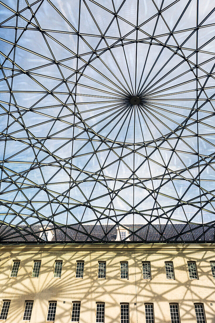 Glasdecke mit kunstvollem Metallgerüst im Innenhof eines Gebäudes mit blauem Himmel,Amsterdam,Niederlande