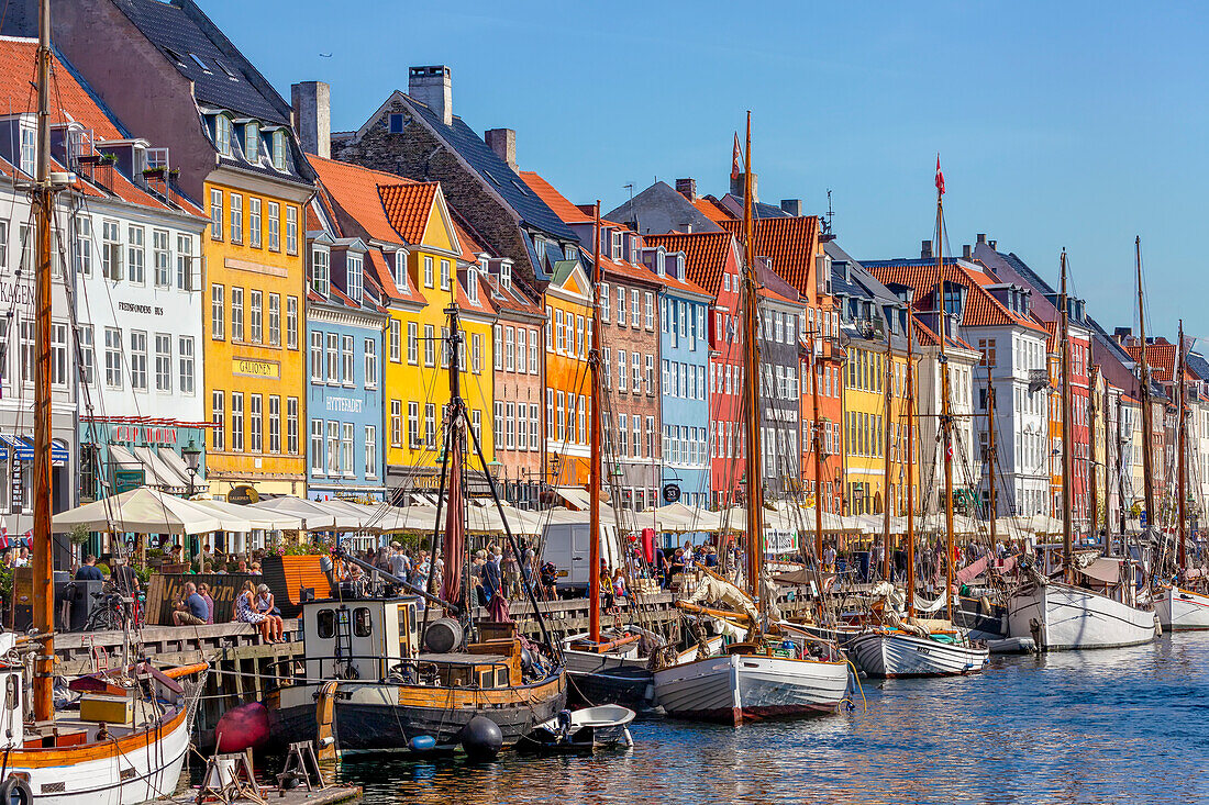 Boote und Menschen entlang des bunten Hafenviertels Nyhavn, Kopenhagen, Dänemark