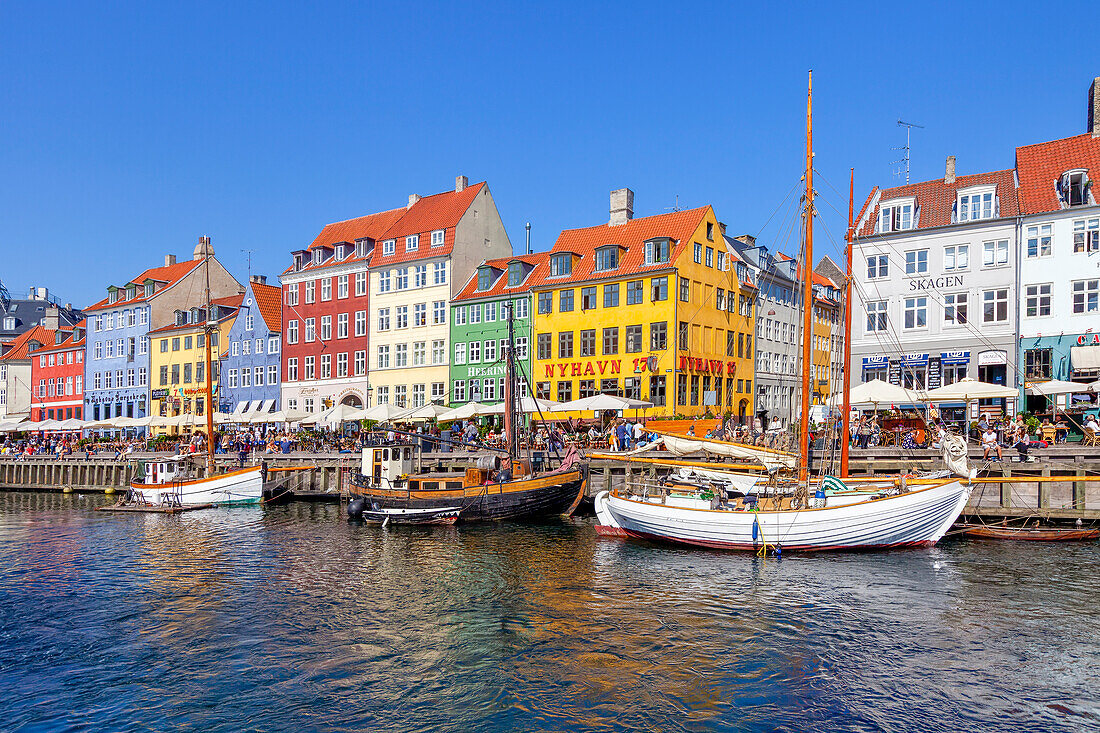 Boote und Menschen entlang des bunten Hafenviertels Nyhavn, Kopenhagen, Dänemark