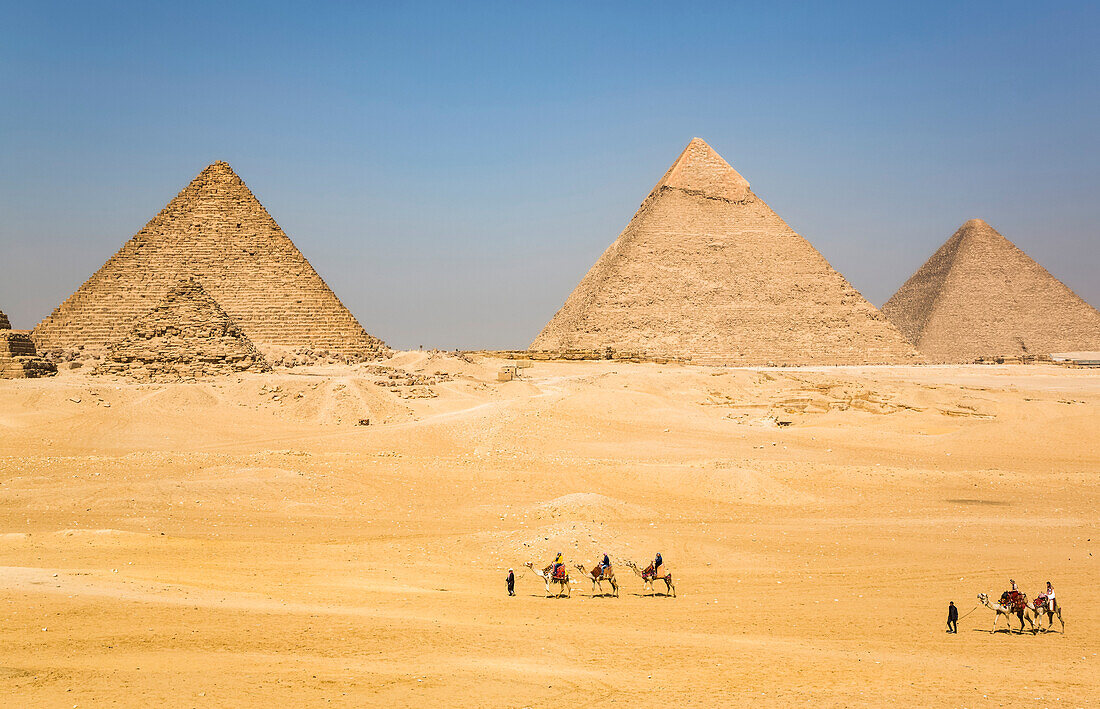 Touristen auf Kamelen, Pyramidenkomplex von Gizeh, UNESCO-Weltkulturerbe, Gizeh, Ägypten