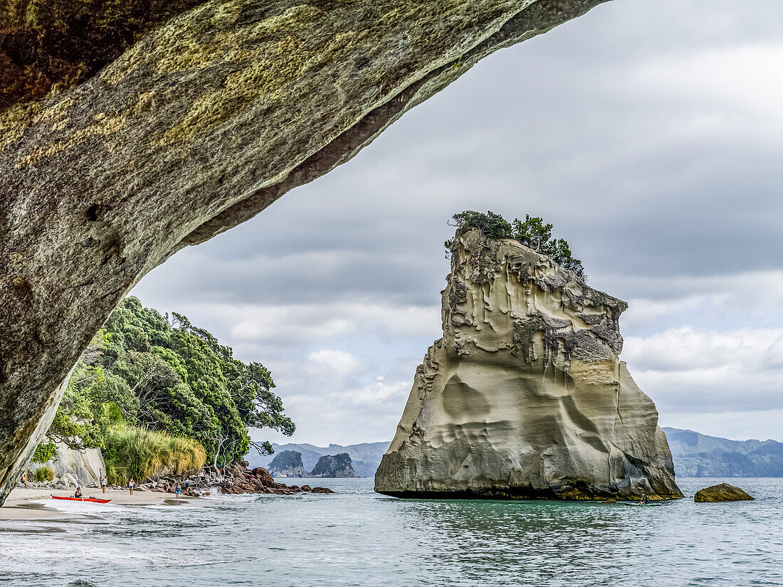 Accessible only on foot or by boat,famous Cathedral Cove is one of the must visit sites on The Coromandel. Tourists enjoying the beach,Waikato Region,New Zealand