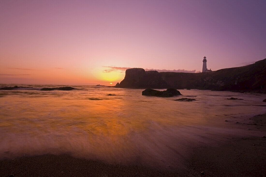 Yaquina Head Light and the surf rolling into shore along the Oregon coast at sunset,Oregon,United States of America