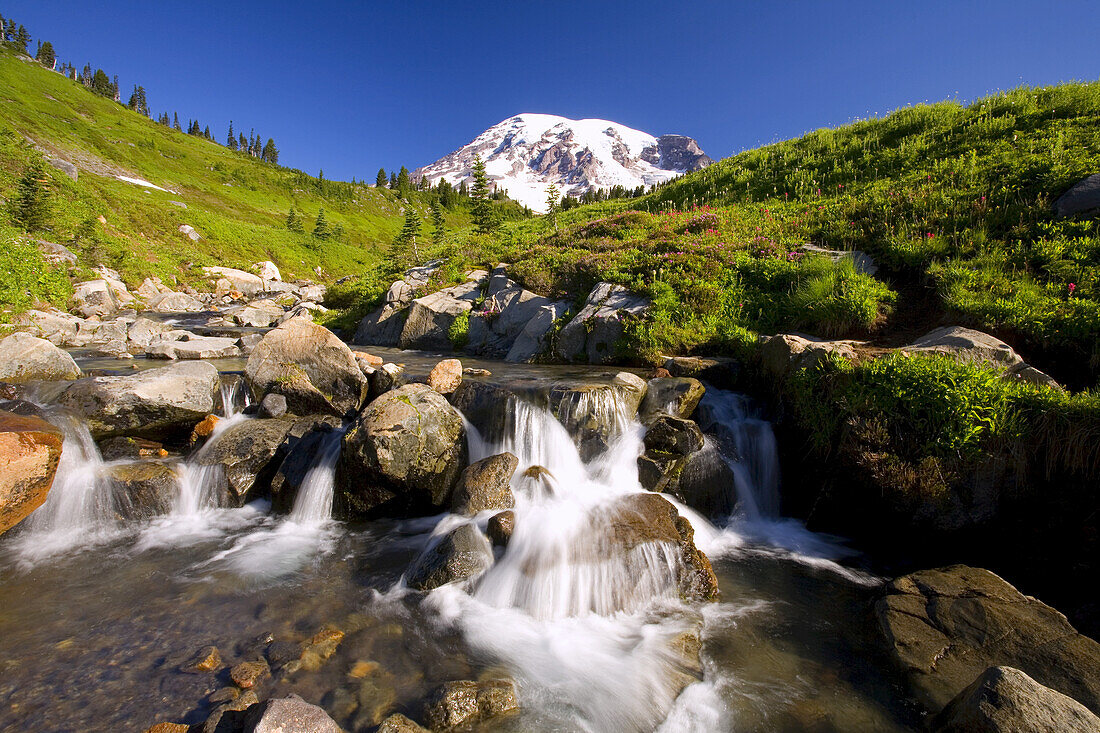 Waterfall in a stream with Mount Rainier in the distance,Mount Rainier National Park,Washington,United States of America