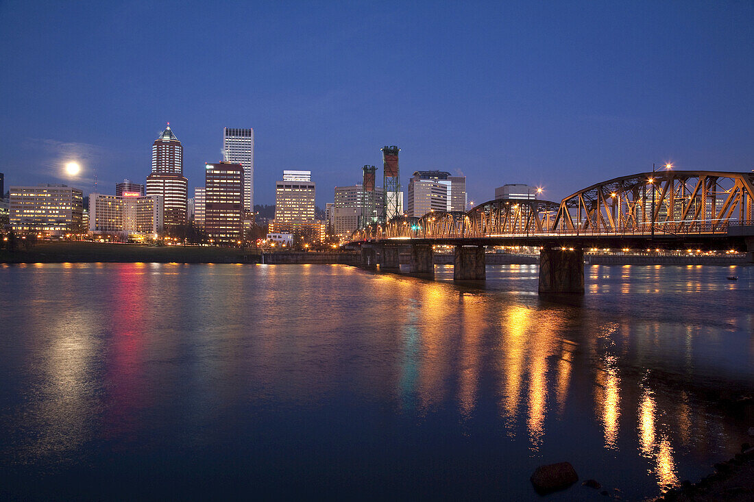 Hawthorne Bridge und die Skyline mit leuchtendem Vollmond entlang des Willamette River in der Abenddämmerung,Portland,Oregon,Vereinigte Staaten von Amerika