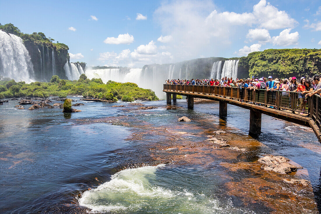 People standing on an observation bridge taking in the amazing Iguazu Falls,Foz do Iguacu,Parana,Brazil