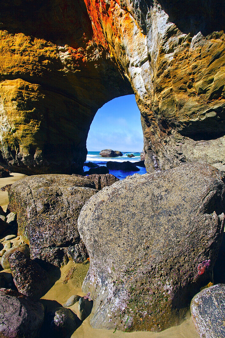 A view of the pacific ocean and horizon through a natural arch and rocks on the rugged Oregon coastline,Newport,Oregon,United States of America