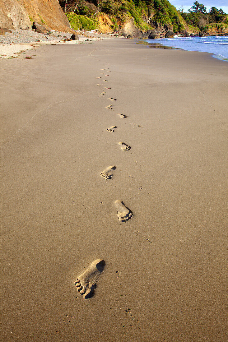 Menschliche Fußabdrücke im Sand an einem Strand entlang der Küste von Oregon, Oregon, Vereinigte Staaten von Amerika